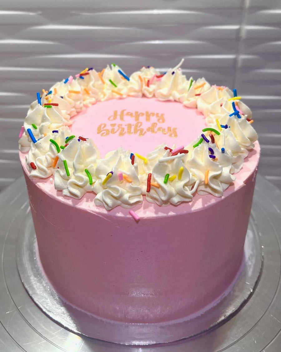 Happy Birthday cake featuring a gold luster dust 'Happy Birthday' message on a fondant topper, available in various colors for personalized celebrations.