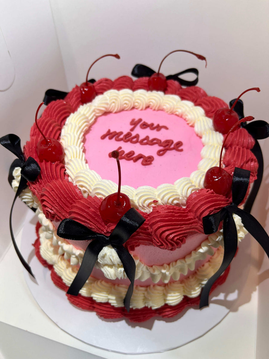 Customizable Bow Cake featuring a vibrant colored bow (black, red, pink, or white) and hand-piped message, perfect for birthdays and special occasions.