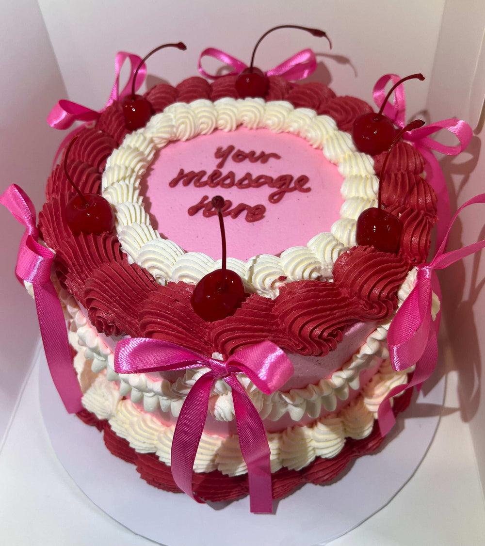 Bow Cake displayed with a decorative pink ribbon bow, custom piping color, and hand-piped message, ideal for any celebration or special occasion.