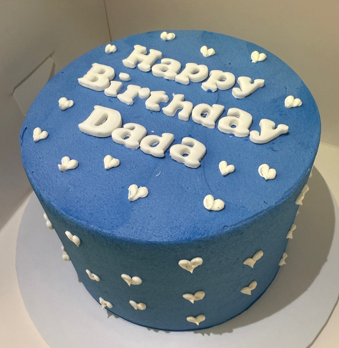 Blue birthday cake with 'Happy Birthday Dada' text on a white background