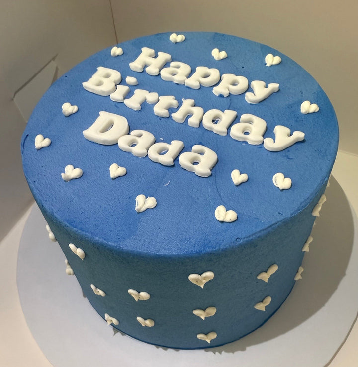 Blue birthday cake with 'Happy Birthday Dada' text on a white background