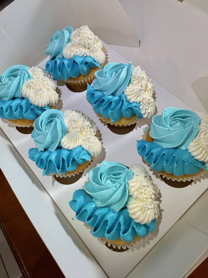 Cupcakes with blue and white frosting in a box