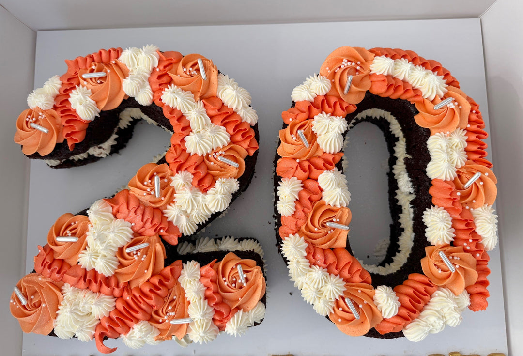 Chocolate Number 20 cake with orange and white frosting on a white background